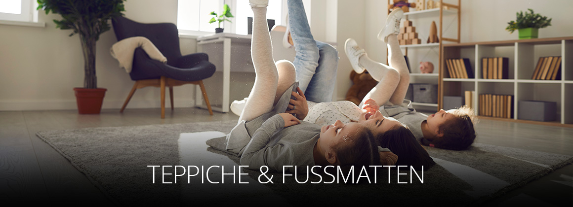 Teppiche & Fußmatten bei OSTERMANN - drei Kinder liegen auf einem Teppich im Wohnzimmer und haben Spaß mit den Beinen in der Luft Fahrrad zu fahren